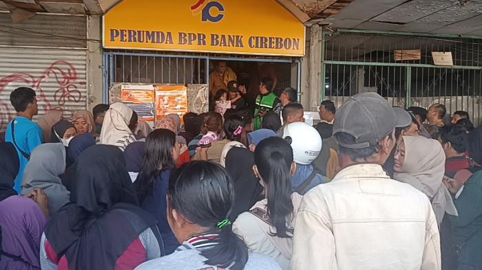 RAMAI-RAMAI KE BANK - Ratusan warga tampak memadati halaman Kantor Perumda BPR Bank Cirebon, Jalan Talang, Kecamatan Lemahwungkuk, Kota Cirebon, Selasa (10/2/2026). Mereka datang silih berganti sejak pagi, menyusul kabar pencabutan izin usaha bank milik daerah tersebut oleh Otoritas Jasa Keuangan (OJK)