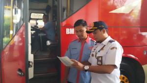 Kepala-Terminal-Jatijajar-Depok-Rafik-Hidayat-mengecek-surat-kendaraan-armada-bus.jpg