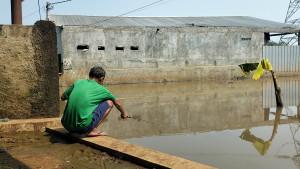 Seorang-warga-memancing-ikan-di-area-banjir-wilayah-Bulak-Barat-Cipayung.jpg