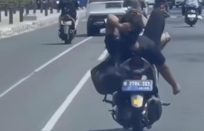 Seorang-pria-nampak-mengendarai-sepeda-motor-sambil-rebahan-di-Jalan-Raya-Margonda.jpg