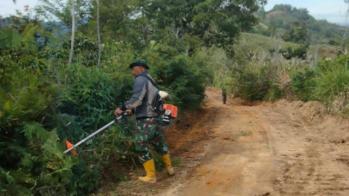 Anggota TNI melakukan finishing akses jalan Kampung Reje Guru, Kabupaten Bener Meriah.