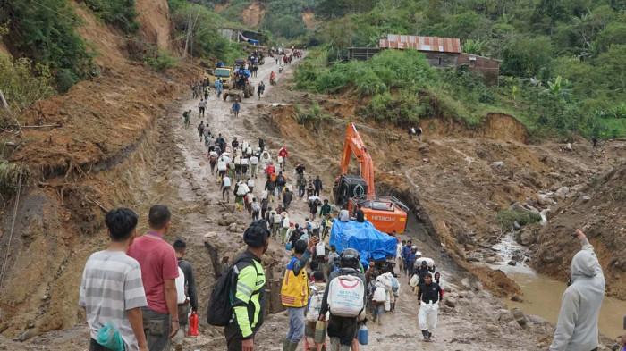 HUT BENER MERIAH - Kondisi Jalan KKA, ratusan warga berjalan kaki menuju Kampung Seni Antara atau Kamp untuk menjual hasil pertanian atau berbelanja kebutuhan pokok, Selasa (16/12/2025).