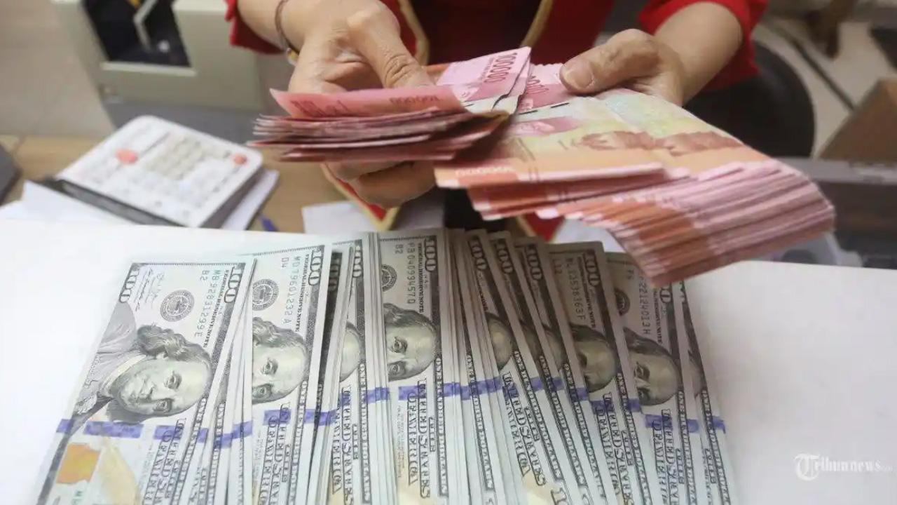 Karyawati-menunjukkan-mata-uang-rupiah-dan-dolar-Amerika-Serikat.jpg