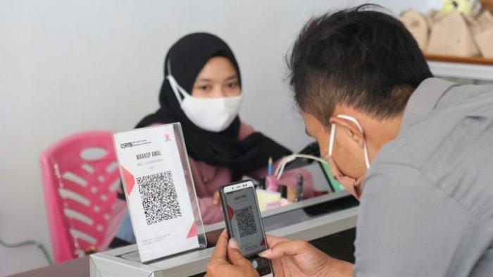 FOTO STOK -- Seorang warga sedang melakukan pembayaran digital menggunakan QRIS.