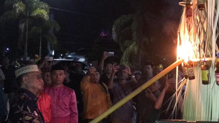 TRADISI TUMBILOTOHE — Bupati Bone Bolango, Gorontalo, Ismet Mile menyalakan lampu botol pertanda memasuki tradisi Timbilotohe di Gorontalo, Senin (16/3/2026). (Sumber foto: TribunGorontalo.com/Jefri Potabuga)