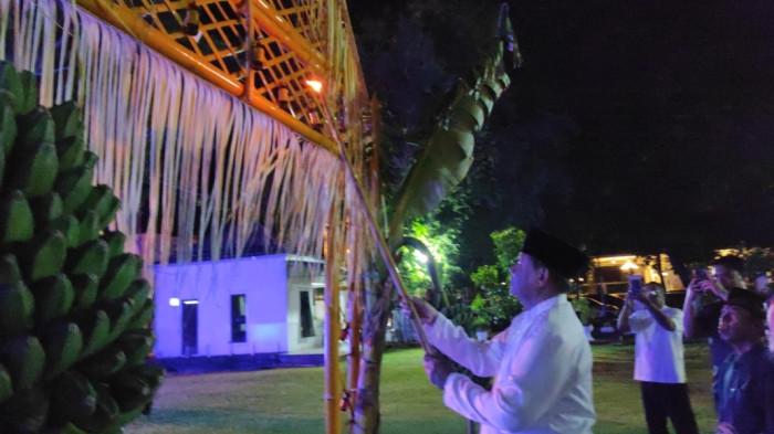 TRADISI TUMBILOTOHE — Gubernur Gorontalo, Gusnar Ismail, menyalakan lampu botol di halaman Rumah Dinas Gubernur, Senin (16/3/2026).