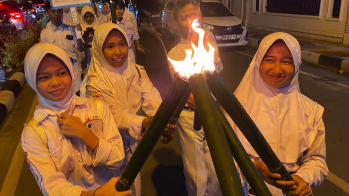 HUT GORONTALO -- Para peserta pawai obor dalam momen HUT ke-298 Kota Gorontalo sedang menyalakan obor yang mati. FOTO: Wawan Akuba