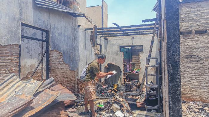 KEBAKARAN RUMAH -- Irwan Hunawa mencari barang-barang yang tersisa akibat kebakaran rumahnya di Kelurahan Huangobotu Kecamatan Dungingi Kota Gorontalo, Selasa (24/3/2026). (Sumber foto: TribunGorontalo.com/Jefri Potabuga)