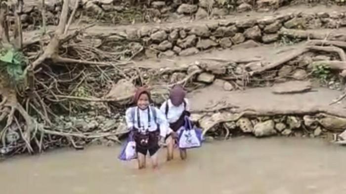 JEMBATAN PUTUS--Potret siswa di Desa Desa Ayumolingo, Kecamatan Pulubala, Kabupaten Gorontalo, Provinsi Gorontalo terpaksa menyeberangi sungai untuk pergi ke sekolah setiap harinya, Selasa (4/11/2025). Sumber foto: Milik warga.