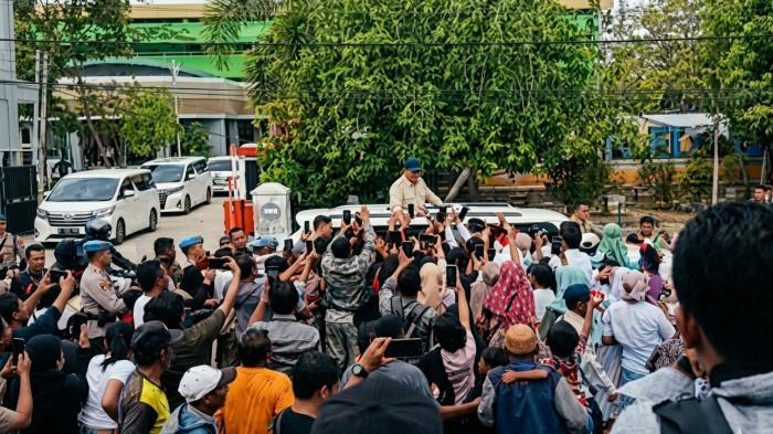 KEDATANGAN -- Momen Prabowo disambut ratusan warga Gorontalo di depan gerbang GOR Nani Wartabone Kota Gorontalo, Sabtu (9/5/2026). Foto ini sudah dipertajam menggunaakan AI Gemini. Sebelumnya foto tampak kabur hasil Live Report reporter TribunGorontalo.com dari lokasi langsung.