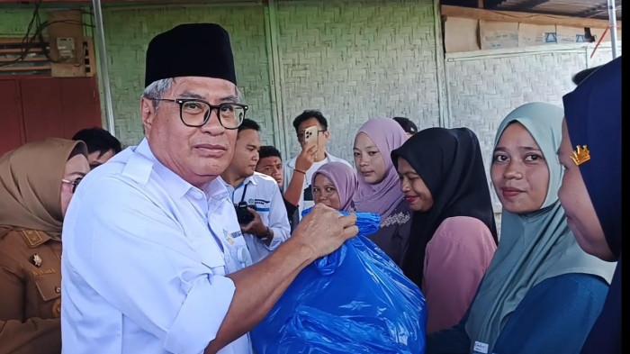 BANTUAN NUTRISI STUNTING - Kepala Badan Kependudukan Keluarga Berencana Nasional (BKKBN) Provinsi Gorontalo Diano Tino Tandaju menyerahkan bantuan secara simbolis kepada para ibu hamil beresiko stunting di Desa Masuru, Kecamatan Kwandang, Kabupaten Gorontalo Utara, Senin (22/9/2025) (Sumber Foto:Efriet Mukmin, TribunGorontalo.com)