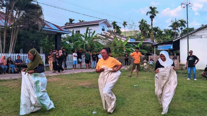 LARI KARUNG -- Tampak tiga emak-emak lari menggunakan karung.