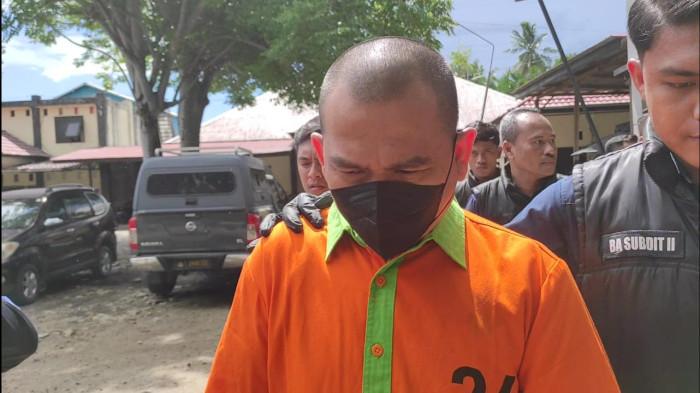 KASUS PENIPUAN -- Mustafa Yasin saat digiring menuju tempat konferensi pers di Mapolda Gorontalo, Selasa (11/11/2025). Mustafa Yasin hanya tertunduk tanpa mengeluarkan sepatah kata pun.