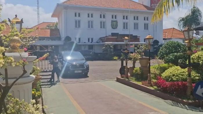 PENGGELEDAHAN - Pihak kepolisian membuka pintu masuk akses keluar masuk saat KPK keluar dari Balai Kota Madiun, Kamis (29/1/2026) sekira pukul 10.00 WIB.Balai Kota diketahui memiliki beberapa ruangan kerja. Diantaranya Ruang Kerja Wali Kota, Ruang Kerja Wakil Wali Kota, Ruang Kerja Sekda, Bagian Umum, Asisten, dan Staf Ahli.