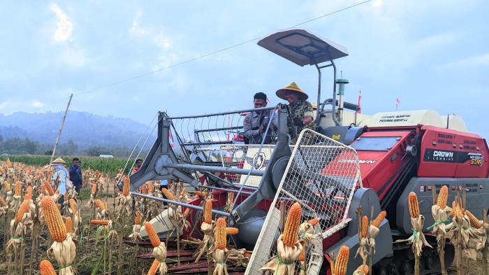 PANEN JAGUNG -- Potret Panglima Kodam (Pangdam) XIII/Merdeka, Mayjen TNI Mirza Agus saat menaiki traktor. Pangdam melakukan panen raya jagung, Rabu (21/1/2026).