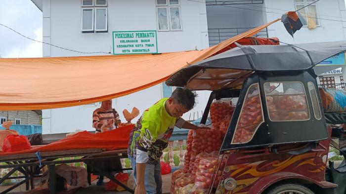 BAHAN POKOK -- Potret pedagang mengangkut pasokan tomat. Harga tomat di Pasar Kamis turun.