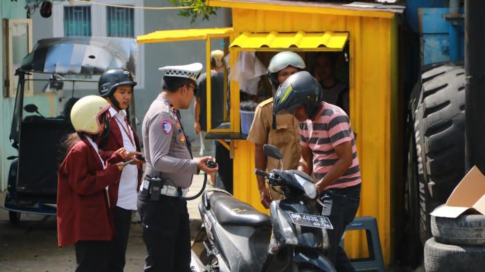 OPERASI KESELAMATAN OTANAHA --Seorang Polantas tengah memeriksa kendaraan milik pria yang berstatus PNS, Selasa (3/2/2026). Ia ditilang polisi karena tidak memiliki SIM dan STNK. (Sumber foto: TribunGorontalo.com/Jefri Potabuga)