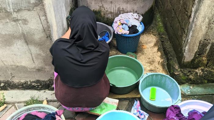 CUCI -- Seorang ibu rumah tangga mencuci pakaian pakai air asin gara-gara tak ada air bersih mengalir ke Pohe, Kota Gorontalo, Kamis (4/9/2025).