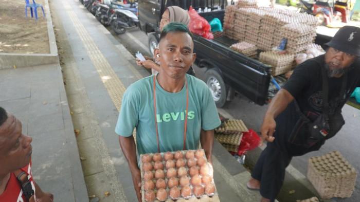 PASAR MURAH -- Seorang warga membawa satu rak telur ayam di Lapangan Taruna Remaja. Pemkot Gorontalo menggelar pasar murah untuk masyarakat Gorontalo.