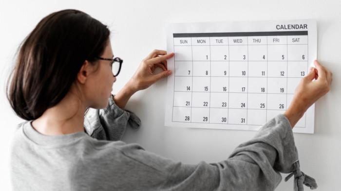 KALENDAR 2026 -- Ilustrasi wanita melihat kalendar. Simak libur nasional dan cuti bersama Mei 2026.