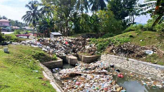 caption: BAU BUSUK - Tumpukan sampah di pinggir jalan dan saluran air di Desa Tambo'o Kecamatan Tilongkabila, Kabupaten Bone Bolango, Provinsi Gorontalo pada Kamis (29/01/2029)