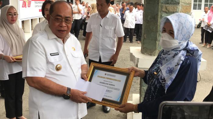 PETUGAS KEBERSIHAN -- Wali Kota Gorontalo, Adhan Dambea saat memberikan penghargaan kepada Hadidjah Igirisa, Rabu (7/1/2026). Hadidjah Igirisa telah bekerja selama 38 tahun. (Sumber foto: TribunGorontalo.com/Jefri Potabuga)