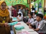 SURAT-PERJANJIAN-Guru-mempersiapkan-kotak-makanan-yang-dibagikan-ke-siswa.jpg
