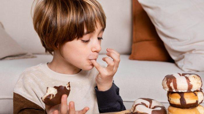 Ilustrasi anak makan cokelat, berikut efek buruk yang bisa terjadi jika cokelat dikonsumsi berlebihan