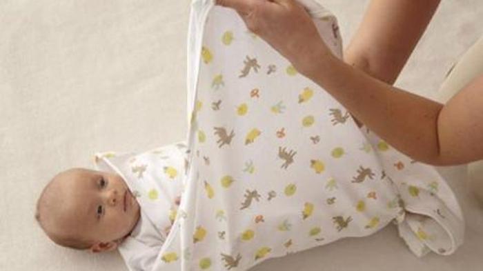 Ilustrasi membedong bayi, berikut sederet manfaat baiknya untuk kesehatan bayi