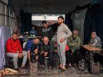 orang-orang-berlindung-dari-hujan-di-aula-yang-menghadap-ke-halaman-sekolah.jpg