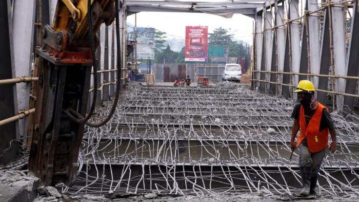 Petugas menggunakan alat berat menghancurkan permukaan aspal dan bantalan beton di Jembatan Citarum Baru, Kecamatan Dayeuhkolot, Kabupaten Bandung, Jawa Barat, Senin (28/7/2025).