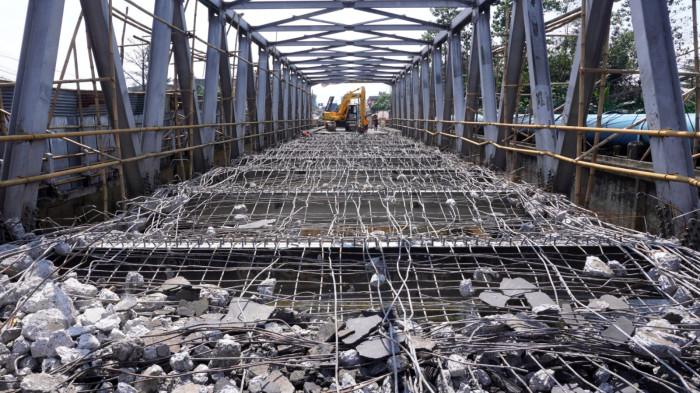 Petugas menggunakan alat berat menghancurkan permukaan aspal dan bantalan beton di Jembatan Citarum Baru, Kecamatan Dayeuhkolot, Kabupaten Bandung, Jawa Barat, Senin (28/7/2025).