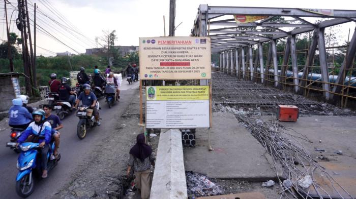 Sejumlah sepeda motor dari arah Dayeuhkolot (kanan) melintas di Jembatan Citarum Lama yang hanya diberlakukan satu arah untuk kendaraan yang dari arah Baleendah, saat proses perbaikan Jembatan Citarum Baru, di Kecamatan Dayeuhkolot, Kabupaten Bandung, Jawa Barat, Senin (28/7/2025).