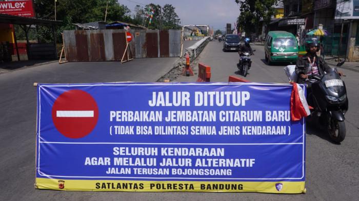 Kendaraan bermotor dari arah Baleendah melintasi Jembatan Citarum Lama, saat proses perbaikan Jembatan Citarum Baru di sebelahnya, di Kecamatan Dayeuhkolot, Kabupaten Bandung, Jawa Barat, Senin (28/7/2025).
