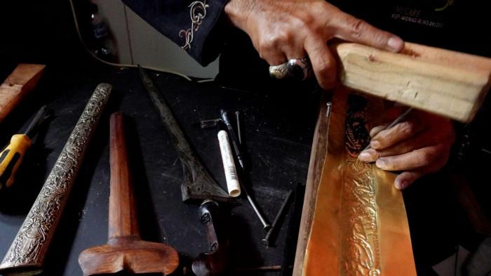 Perajin keris membuat sarung keris atau warangka pada Pameran Nasional Pusaka Nusantara di Museum Sri Baduga, Kota Bandung, Jawa Barat, Selasa (29/7/2025).