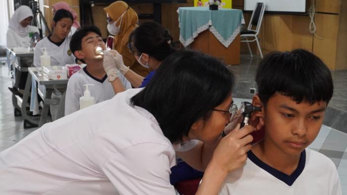 Pelajar mengikuti cek kesehatan saat pelaksanaan program Cek Kesehatan Gratis (CKG) Untuk Anak Sekolah Menengah Pertama di SMPN 5 Kota Bandung, Jawa Barat, Senin (4/8/2025).