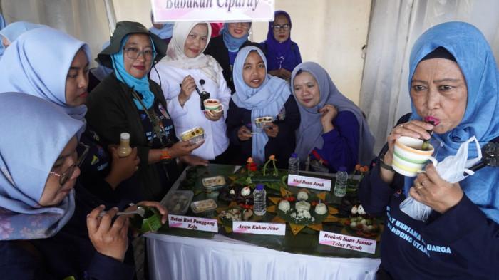 Ibu-ibu menikmati makanan sehat dan lezat hasil kreasi ibu-ibu peserta selesai dinilai dewan juri dalam Lomba Kreasi Menu Dapur Sehat Atasi Stunting (DASHAT) 2025, di Tamansari Laswi City, Kota Bandung, Jawa Barat, Rabu (6/8/2025).