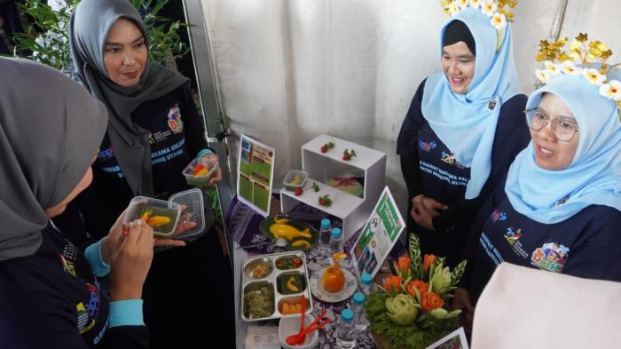 Ibu-ibu menikmati makanan sehat dan lezat hasil kreasi ibu-ibu peserta selesai dinilai dewan juri dalam Lomba Kreasi Menu Dapur Sehat Atasi Stunting (DASHAT) 2025, di Tamansari Laswi City, Kota Bandung, Jawa Barat, Rabu (6/8/2025).