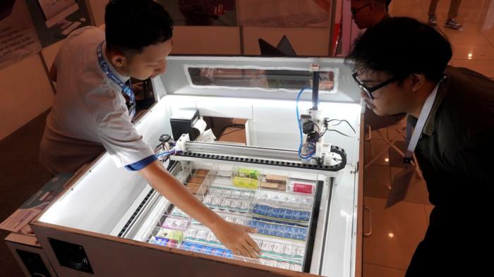 Pengunjung mengamati Mesin Anjungan Obat Mandiri (AOM) yang diproduksi oleh Paperless Hospital pada gelaran Radiology & Hospital Equipment Expo (Radex) 2025 di Graha Manggala Siliwangi, Kota Bandung, Jawa Barat, Jumat (8/8/2025).