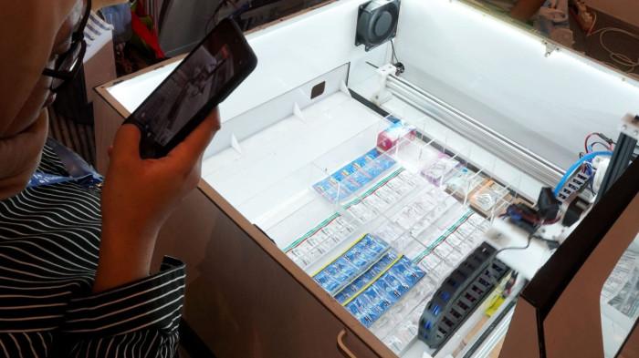 Pengunjung mengamati Mesin Anjungan Obat Mandiri (AOM) yang diproduksi oleh Paperless Hospital pada gelaran Radiology & Hospital Equipment Expo (Radex) 2025 di Graha Manggala Siliwangi, Kota Bandung, Jawa Barat, Jumat (8/8/2025).