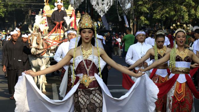Iring-iringan Kirab Sang Merah Putih, mengantarkan bendera Merah Putih ke tempat upacara menggunakan kereta kencana, melintas di Jalan Diponegoro, Kota Bandung, Jawa Barat, Minggu (17/8/2025).