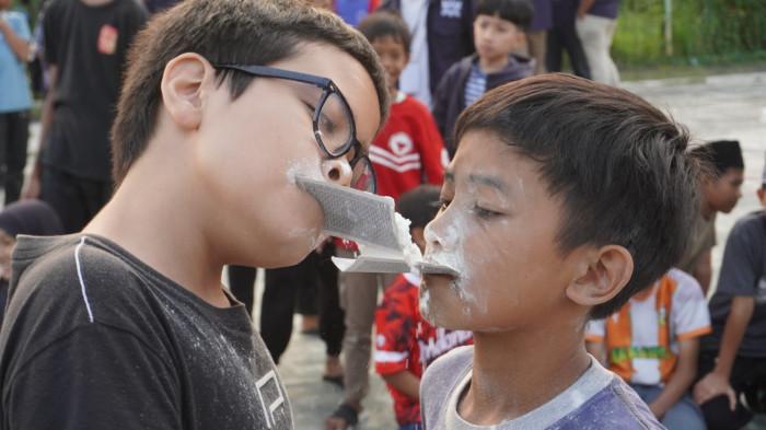 Sejumlah anak mengikuti lomba estafet tepung pada kegiatan memperingati HUT ke-80 Republik Indonesia, di Rancamanyar Regency 1, Desa Rancamanyar, Kecamatan Baleendah, Kabupaten Bandung, Jawa Barat, Minggu (17/8/2025).
