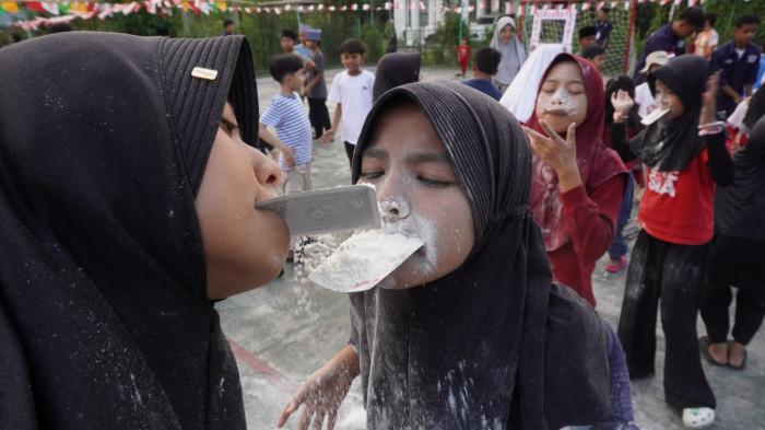 Sejumlah anak mengikuti lomba estafet tepung pada kegiatan memperingati HUT ke-80 Republik Indonesia, di Rancamanyar Regency 1, Desa Rancamanyar, Kecamatan Baleendah, Kabupaten Bandung, Jawa Barat, Minggu (17/8/2025).