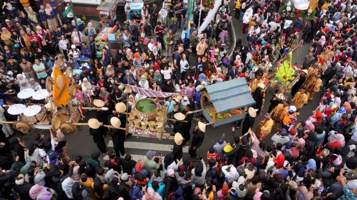 Warga menyaksikan Kirab Budaya dalam rangka memperingati Hari Jadi ke-80 Provinsi Jawa Barat, di Kota Bandung, Jawa Barat, Selasa (19/8/2025).
