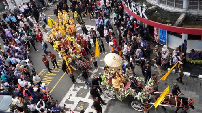 Warga menyaksikan Kirab Budaya dalam rangka memperingati Hari Jadi ke-80 Provinsi Jawa Barat, di Kota Bandung, Jawa Barat, Selasa (19/8/2025).