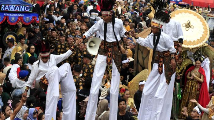 Warga menyaksikan Kirab Budaya dalam rangka memperingati Hari Jadi ke-80 Provinsi Jawa Barat, di Kota Bandung, Jawa Barat, Selasa (19/8/2025).