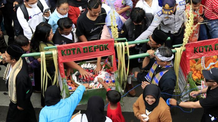 Warga mengambil hidangan yang dibawa peserta Kirab Budaya dalam rangka memperingati Hari Jadi ke-80 Provinsi Jawa Barat, di Kota Bandung, Jawa Barat, Selasa (19/8/2025).