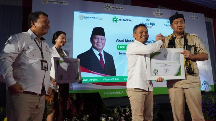 Menteri Perumahan dan Kawasan Permukiman Maruarar Sirait (kanan), memberikan penghargaan kepada Direktur Utama Bank BJB Yusuf Saadudin dan Direktur Utama Bank BJB syariah Arief Setyahadi pada acara Akad Massal dan Serah Terima Kunci 1.080 Debitur FLPP Bank BJB dan Bank BJB Syariah di Kawasan Pabrik Kahatex, Jalan Raya Garut - Bandung, Kabupaten Sumedang, Jawa Barat, Jumat (22/8/2025).
