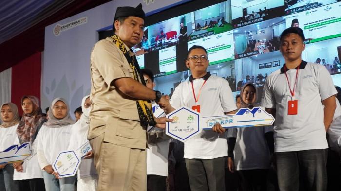 Menteri Perumahan dan Kawasan Permukiman Maruarar Sirait, simbolis memerikan kunci rumah kepada debitur FLPP pada acara Akad Massal dan Serah Terima Kunci 1.080 Debitur FLPP Bank BJB dan Bank BJB Syariah di Kawasan Pabrik Kahatex, Jalan Raya Garut - Bandung, Kabupaten Sumedang, Jawa Barat, Jumat (22/8/2025).