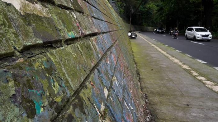 Pengguna jalan melintas di samping mural yang sudah kusam di Jalan Siliwangi (Babakan Siliwangi), Kota Bandung, Jawa Barat, Jumat (22/8/2025).